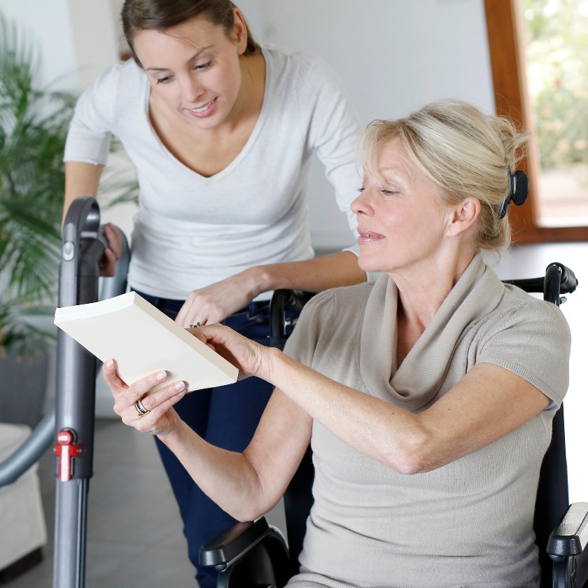 Young woman helping disabled lady at home
